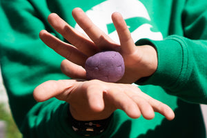person holding squish aromatherapy play dough in their hands. Squish Therapy Dough Relax purple lavender stress relief dough